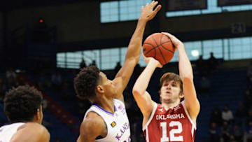 Jan 9, 2021; Lawrence, Kansas, USA; Oklahoma Sooners guard Austin Reaves (12) shoots a jump shot as Kansas Jayhawks guard Ochai Agbaji (30) defends during the game at Allen Fieldhouse. Mandatory Credit: Denny Medley-USA TODAY Sports