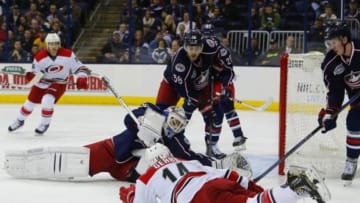 Nov 4, 2014; Columbus, OH, USA; Columbus Blue Jackets goalie Curtis McElhinney (30) makes a save on a shot from a sliding Carolina Hurricanes left wing Nathan Gerbe (14) during the third period at Nationwide Arena. Carolina defeated Columbus 4-2. Mandatory Credit: Russell LaBounty-USA TODAY Sports