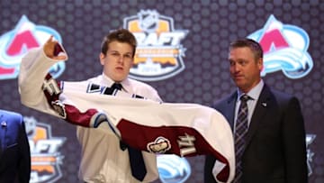 Jun 27, 2014; Philadelphia, PA, USA; Conner Bleackley (left) puts on a team sweater in front of head coach Patrick Roy after being selected as the number twenty-three overall pick to the Colorado Avalanche in the first round of the 2014 NHL Draft at Wells Fargo Center. Mandatory Credit: Bill Streicher-USA TODAY Sports