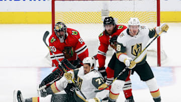 Corey Crawford #50 of the Chicago Blackhawks and Ryan Reaves #75 of the Vegas Golden Knights (Photo by Jeff Vinnick/Getty Images)