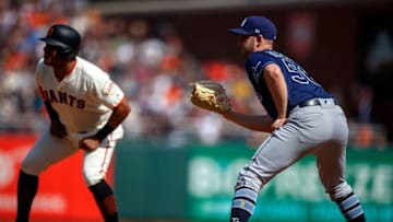 SAN FRANCISCO, CA - APRIL 07: Adam Kolarek #56 of the Tampa Bay Rays holds Yangervis Solarte #26 of the San Francisco Giants on first base during the seventh inning at Oracle Park on April 7, 2019 in San Francisco, California. Kolarek was moved to first base from pitcher in between batters. The Tampa Bay Rays defeated the San Francisco Giants 3-0. (Photo by Jason O. Watson/Getty Images)