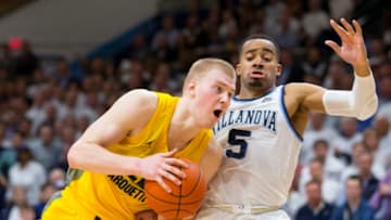VILLANOVA, PA - FEBRUARY 27: Joey Hauser #22 of the Marquette Golden Eagles drives to the basket against Phil Booth #5 of the Villanova Wildcats in the second half at Finneran Pavilion on February 27, 2019 in Villanova, Pennsylvania. The Villanova Wildcats defeated the Marquette Golden Eagles 67-61. (Photo by Mitchell Leff/Getty Images)