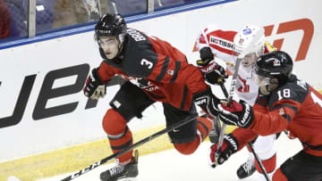 VICTORIA , BC - DECEMBER 19: Josh Brook #3 and Markus Phillips #18 of Team Canada battle with Ian Derungs #27 of Team Switzerland at the IIHF World Junior Championships at the Save-on-Foods Memorial Centre on December 19, 2018 in Victoria, British Columbia, Canada. Canada defeated Switzerland 5-3. (Photo by Kevin Light/Getty Images)"n"n"n"n