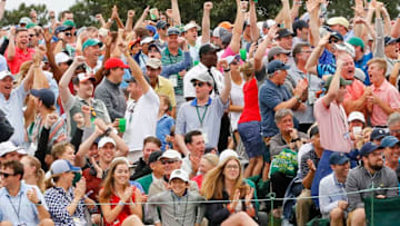 AUGUSTA, GEORGIA - APRIL 14: Patrons cheer on the 18th green after Tiger Woods of the United States score is updated on the leaderboard during the final round of the Masters at Augusta National Golf Club on April 14, 2019 in Augusta, Georgia. (Photo by Kevin C. Cox/Getty Images)