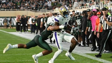 Sep 16, 2023; East Lansing, Michigan, USA; Washington Huskies wide receiver Germie Bernard (4) catches the ball before being forced out of bounds by Michigan State Spartans defensive back Dillon Tatum (21) in the third quarter at Spartan Stadium. Mandatory Credit: Dale Young-USA TODAY Sports