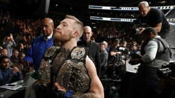 Nov 12, 2016; New York, NY, USA; Conor McGregor (blue gloves) celebrates with his two championship belts after defeating Eddie Alvarez (red gloves) in their lightweight title bout during UFC 205 at Madison Square Garden. Mandatory Credit: Adam Hunger-USA TODAY Sports
