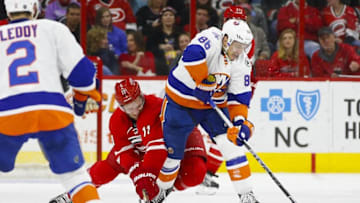 Mar 26, 2016; Raleigh, NC, USA; New York Islanders forward Nikolay Kulemin (86) tries to control the puck against Carolina Hurricanes forward Jordan Staal (11) during the second period at PNC Arena. Mandatory Credit: James Guillory-USA TODAY Sports