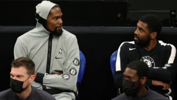 BOSTON, MASSACHUSETTS - DECEMBER 18: Kevin Durant #7 of the Brooklyn Nets and Kyrie Irving #11 talk together on the bench during the preseason game against the Boston Celtics at TD Garden on December 18, 2020 in Boston, Massachusetts. NOTE TO USER: User expressly acknowledges and agrees that, by downloading and or using this photograph, User is consenting to the terms and conditions of the Getty Images License Agreement. (Photo by Maddie Meyer/Getty Images)