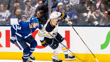 TORONTO, ON - DECEMBER 17: Justin Holl #3 of the Toronto Maple Leafs battles against Jack Eichel #9 of the Buffalo Sabres during the second period at the Scotiabank Arena on December 17, 2019 in Toronto, Ontario, Canada. (Photo by Mark Blinch/NHLI via Getty Images)
