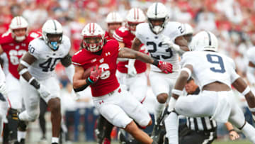 Sep 4, 2021; Madison, Wisconsin, USA; Wisconsin Badgers running back Chez Mellusi (6) rushes with the football as Penn State Nittany Lions cornerback Joey Porter Jr. (9) defends during the first quarter at Camp Randall Stadium. Mandatory Credit: Jeff Hanisch-USA TODAY Sports