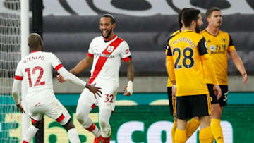 Southampton's English midfielder Theo Walcott (2nd L) celebrates with Southampton's Malian midfielder Moussa Djenepo after scoring the opening goal of the English Premier League football match between Wolverhampton Wanderers and Southampton at the Molineux stadium in Wolverhampton, central England on November 23, 2020. (Photo by ANDREW BOYERS / POOL / AFP) / RESTRICTED TO EDITORIAL USE. No use with unauthorized audio, video, data, fixture lists, club/league logos or 'live' services. Online in-match use limited to 120 images. An additional 40 images may be used in extra time. No video emulation. Social media in-match use limited to 120 images. An additional 40 images may be used in extra time. No use in betting publications, games or single club/league/player publications. / (Photo by ANDREW BOYERS/POOL/AFP via Getty Images)