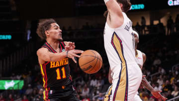 Mar 20, 2022; Atlanta, Georgia, USA; Atlanta Hawks guard Trae Young (11) passes around New Orleans Pelicans center Jonas Valanciunas (17) during the first half at State Farm Arena. Mandatory Credit: Dale Zanine-USA TODAY Sports