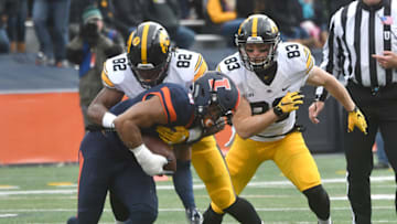 CHAMPAIGN, IL - NOVEMBER 19: Iowa wide receiver Adrian Falconer (82) and Iowa Hawkeyes wide receiver Riley McCarron (83) tackle Illinois defensive back Dillan Cazley (8) after a pass interception during a Big Ten Conference football game between the University of Iowa Hawkeyes and the University of Illinois Fighting Illini on November 19, 2016, at Memorial Stadium in Champaign, IL. (Photo by Keith Gillett/Icon Sportswire via Getty Images)