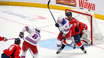 WASHINGTON, DC - OCTOBER 18: New York Rangers defenseman Jacob Trouba (8) takes a shot as right wing Jesper Fast (17) fights for position with Washington Capitals center Lars Eller (20) on October 18, 2019, at the Capital One Arena in Washington, D.C. (Photo by Mark Goldman/Icon Sportswire via Getty Images)