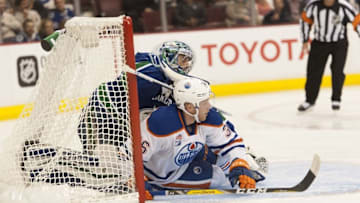 Sep 28, 2016; Vancouver, British Columbia, CAN; Edmonton Oilers center Drake Caggiula (36) collides with Vancouver Canucks goalie Ryan Miller (30) in the second period during a preseason hockey game at Rogers Arena. Mandatory Credit: Peter Llewellyn-USA TODAY Sports