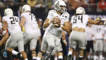 Jan 12, 2015; Arlington, TX, USA; Oregon Ducks quarterback Marcus Mariota (8) rolls out of the pocket against the Ohio State Buckeyes in the 2015 CFP National Championship Game at AT&T Stadium. Mandatory Credit: Matthew Emmons-USA TODAY Sports