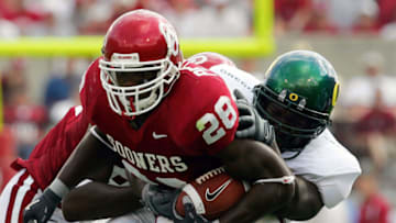 NORMAN, OK - SEPTEMBER 18: Running back Adrian Peterson #28 of the Oklahoma Sooners is tackled by Darius Sanders #95 of the University of Oregon Ducks on September 18, 2004 at Memorial Stadium in Norman, Oklahoma. (Photo by Ronald Martinez/Getty Images)