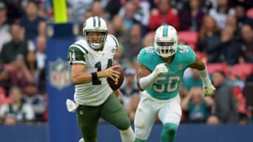 Oct 4, 2015; London, United Kingdom; New York Jets quarterback Ryan Fitzpatrick (14) carries the ball while pursued by Miami Dolphins right end Oliver Vernon (50) in Game 12 of the NFL International Series at Wembley Stadium.The Jets defeated the Dolphins 27-14. Mandatory Credit: Kirby Lee-USA TODAY Sports