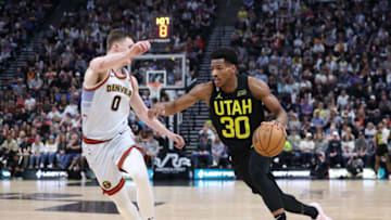 Apr 8, 2023; Salt Lake City, Utah, USA; Utah Jazz guard Ochai Agbaji (30) dribbles the ball against Denver Nuggets guard Christian Braun (0) in the fourth quarter at Vivint Arena. Mandatory Credit: Rob Gray-USA TODAY Sports