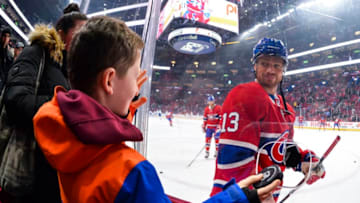MONTREAL, QC - FEBRUARY 08: Max Domi #13 of the Montreal Canadiens hands a puck over to a young fan during the warm-up against the Toronto Maple Leafs at the Bell Centre on February 8, 2020 in Montreal, Canada. The Montreal Canadiens defeated the Toronto Maple Leafs 2-1 in overtime. (Photo by Minas Panagiotakis/Getty Images)