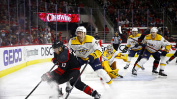 RALEIGH, NORTH CAROLINA - MAY 19: Warren Foegele #13 of the Carolina Hurricanes plays the puck while defended by Filip Forsberg #9 of the Nashville Predators during the third period in Game Two of the First Round of the 2021 Stanley Cup Playoffs at PNC Arena on May 19, 2021 in Raleigh, North Carolina. (Photo by Jared C. Tilton/Getty Images)