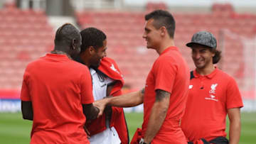 STOKE ON TRENT, ENGLAND - AUGUST 09: Mamadou Sakho of Liverpool (L) dresses ex-Liverpool player Glen Johnson of Stoke City in a Liverpool tracksuit top as Dejan Lovren (2R) and Lazar Markovic of Liverpool (R) look on prior to the Barclays Premier League match between Stoke City and Liverpool at Brittania Stadium on August 9, 2015 in Stoke on Trent, England. (Photo by Michael Regan/Getty Images)
