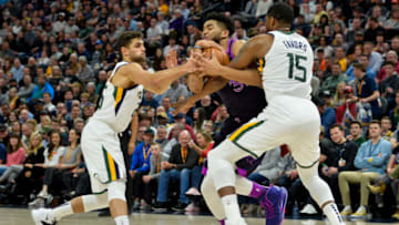 SALT LAKE CITY, UT - MARCH 14: Karl-Anthony Towns #32 of the Minnesota Timberwolves drives between Derrick Favors #15 and Raul Neto #25 of the Utah Jazz during a game at Vivint Smart Home Arena on March 14, 2019 in Salt Lake City, Utah. NOTE TO USER: User expressly acknowledges and agrees that, by downloading and or using this photograph, User is consenting to the terms and conditions of the Getty Images License Agreement. (Photo by Alex Goodlett/Getty Images)