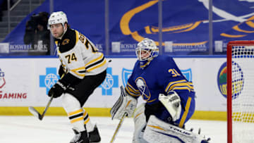 Apr 22, 2021; Buffalo, New York, USA; Boston Bruins left wing Jake DeBrusk (74) and Buffalo Sabres goaltender Dustin Tokarski (31) look for the puck during the first period at KeyBank Center. Mandatory Credit: Timothy T. Ludwig-USA TODAY Sports