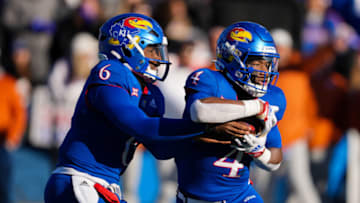 Nov 19, 2022; Lawrence, Kansas, USA; Kansas Jayhawks running back Devin Neal (4) takes the handoff from quarterback Jalon Daniels (6) during the first half against the Texas Longhorns at David Booth Kansas Memorial Stadium. Mandatory Credit: Jay Biggerstaff-USA TODAY Sports