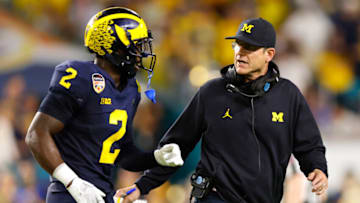 MIAMI GARDENS, FLORIDA - DECEMBER 31: Head Coach Jim Harbaugh of the Michigan Wolverines talks with Brad Hawkins #2 of the Michigan Wolverines in the second quarter of the game against the Georgia Bulldogs in the Capital One Orange Bowl for the College Football Playoff semifinal game at Hard Rock Stadium on December 31, 2021 in Miami Gardens, Florida. (Photo by Michael Reaves/Getty Images)