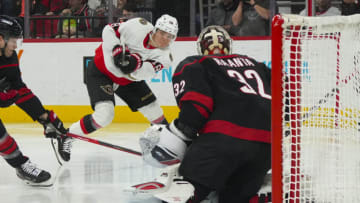 Feb 24, 2023; Raleigh, North Carolina, USA; Ottawa Senators left wing Tim Stützle (18) takes a shot on Carolina Hurricanes goaltender Antti Raanta (32) during the second period at PNC Arena. Mandatory Credit: James Guillory-USA TODAY Sports