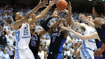 CHAPEL HILL, NORTH CAROLINA - MARCH 09: Teammates Javin DeLaurier #12 and RJ Barrett #5 of the Duke Blue Devils battle for a loose ball against Garrison Brooks #15 and Luke Maye #32 of the North Carolina Tar Heels during their game at Dean Smith Center on March 09, 2019 in Chapel Hill, North Carolina. (Photo by Streeter Lecka/Getty Images)