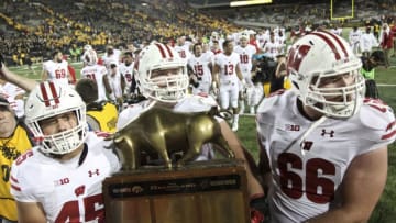 IOWA CITY, IOWA- SEPTEMBER 22: Fullback Alec Ingold #45, offensive lineman Michael Dieter #63 and offensive lineman Tyler Beach #65 of the Wisconsin Badgers carry the Heartland Trophy off the field after defeating the Iowa Hawkeyes, on September 22, 2018 at Kinnick Stadium, in Iowa City, Iowa. (Photo by Matthew Holst/Getty Images)