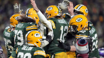 GREEN BAY, WISCONSIN - JANUARY 02: Quarterback Aaron Rodgers #12 of the Green Bay Packers is celebrates with teammates after a touchdown during the 4th quarter of the game against the Minnesota Vikings at Lambeau Field on January 02, 2022 in Green Bay, Wisconsin. (Photo by Patrick McDermott/Getty Images)