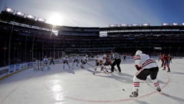 Jan 1, 2015; Washington, DC, USA; Chicago Blackhawks center Jonathan Toews (19) wins a face off and passes the puck to defenseman Brent Seabrook (right) in the first period against the Washington Capitals during the 2015 Winter Classic hockey game at Nationals Park. Mandatory Credit: Geoff Burke-USA TODAY Sports
