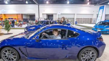 Payton Wille, 16, of Kenosha, smiles as he checks out a 2022 Subaru BRZ while his brother Eli ,13 stands outside the car. They were with their parents, Sam and Todd Wille, during the 2022 Greater Milwaukee International Car & Truck Show at the Wisconsin Center in Milwaukee on Sunday, Feb. 27, 2022. The show continues through March 6, and features about 400 new cars and trucks from a diverse set of brands.Wild Autoshow 0395
