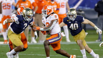 CHARLOTTE, NORTH CAROLINA - DECEMBER 19: Defensive lineman Isaiah Foskey #7 of the Notre Dame Fighting Irish attempts to tackle running back Travis Etienne #9 of the Clemson Tigers in the second quarter during the ACC Championship game at Bank of America Stadium on December 19, 2020 in Charlotte, North Carolina. (Photo by Jared C. Tilton/Getty Images)