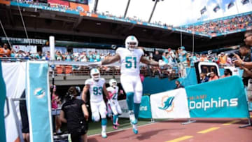 Oct 12, 2014; Miami Gardens, FL, USA; Miami Dolphins center Mike Pouncey (51) and Miami Dolphins middle linebacker Jason Trusnik (93) head onto the field at Sun Life Stadium. Mandatory Credit: Brad Barr-USA TODAY Sports