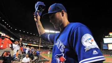 Jun 17, 2016; Baltimore, MD, USA; Toronto Blue Jays outfielder Michael Saunders (21) celebrates after beating the Baltimore Orioles 13-3 at Oriole Park at Camden Yards. Saunders was holding up a hat that was thrown on the field by a fan after hitting his third home run of the game. Mandatory Credit: Evan Habeeb-USA TODAY Sports