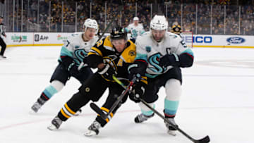 BOSTON, MA - FEBRUARY 1: Brad Marchand #63 of the Boston Bruins checks Mark Giordano #5 of the Seattle Kraken during the third period at the TD Garden on February 1, 2022 in Boston, Massachusetts. The Bruins won 3-2. (Photo by Rich Gagnon/Getty Images)