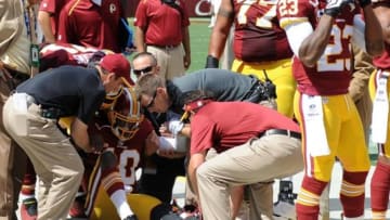 Sep 14, 2014; Landover, MD, USA; Washington Redskins quarterback Robert Griffin (10) is helped to his feet after suffering an apparent injury against the Jacksonville Jaguars during the first half at FedEx Field. Mandatory Credit: Brad Mills-USA TODAY Sports