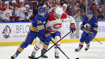 Mar 27, 2023; Buffalo, New York, USA; Buffalo Sabres center Dylan Cozens (24) and Montreal Canadiens center Nick Suzuki (14) battle for a loose puck during the first period at KeyBank Center. Mandatory Credit: Timothy T. Ludwig-USA TODAY Sports