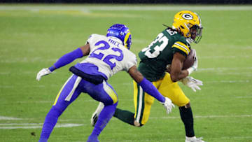 GREEN BAY, WISCONSIN - JANUARY 16: Aaron Jones #33 of the Green Bay Packers runs with the ball against Troy Hill #22 of the Los Angeles Rams in the first half during the NFC Divisional Playoff game at Lambeau Field on January 16, 2021 in Green Bay, Wisconsin. (Photo by Dylan Buell/Getty Images)