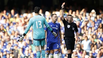 Referee Michael Oliver (R) shows the red card to send off Chelsea's Belgian goalkeeper Thibaut Courtois (L) after a foul on Swansea City's French striker Bafetimbi Gomis (unseen) conceeded a penalty as Chelsea's English defender John Terry (C) reacts during the English Premier League football match between Chelsea and Swansea City at Stamford Bridge in London on August 8, 2015. AFP PHOTO / ADRIAN DENNISRESTRICTED TO EDITORIAL USE. No use with unauthorized audio, video, data, fixture lists, club/league logos or 'live' services. Online in-match use limited to 75 images, no video emulation. No use in betting, games or single club/league/player publications. (Photo credit should read ADRIAN DENNIS/AFP/Getty Images)