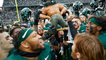 Oct 30, 2021; East Lansing, Michigan, USA; Members of the Michigan State Spartans hold up the Paul Bunyan trophy in celebration after the game against the Michigan Wolverines at Spartan Stadium. Mandatory Credit: Raj Mehta-USA TODAY Sports