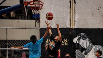 MANILA, PHILIPPINES - AUGUST 22: Children play basketball next to a mural of Filipino-American NBA player Jordan Clarkson, at a tenement building ahead of the FIBA World Cup on August 22, 2023 in Taguig, Metro Manila, Philippines. The basketball world cup starts on August 25 in Philippines, Indonesia and Japan. (Photo by Ezra Acayan/Getty Images)