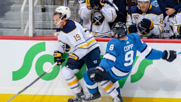 WINNIPEG, MB - NOVEMBER 16: Andrew Copp #9 of the Winnipeg Jets falls to the ice after colliding along the boards with Jake McCabe #19 of the Buffalo Sabres during third period action at the Bell MTS Place on November 16, 2018 in Winnipeg, Manitoba, Canada. (Photo by Jonathan Kozub/NHLI via Getty Images)