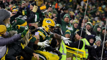GREEN BAY, WISCONSIN - NOVEMBER 14: A.J. Dillon #28 of the Green Bay Packers celebates with fans after scoring a touchdown against the Seattle Seahawks during the fourth quarter at Lambeau Field on November 14, 2021 in Green Bay, Wisconsin. (Photo by Stacy Revere/Getty Images)