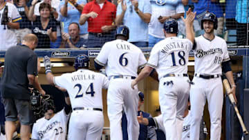 MILWAUKEE, WI - AUGUST 08: Jesus Aguilar #24, Lorenzo Cain #6, and Mike Moustakas #18 of the Milwaukee Brewers celebrate after Aguilar hit a home run in the first inning sd at Miller Park on August 8, 2018 in Milwaukee, Wisconsin. (Photo by Dylan Buell/Getty Images)