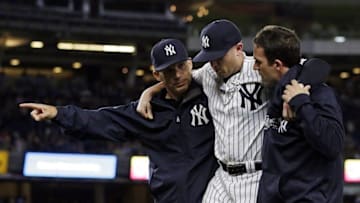 Jun 9, 2016; Bronx, NY, USA; New York Yankees first baseman Chris Parmelee is helped off the field by manager Joe Girardi (L) and a team trainer after injuring himself during the seventh inning against the Los Angeles Angels at Yankee Stadium. Mandatory Credit: Adam Hunger-USA TODAY Sports